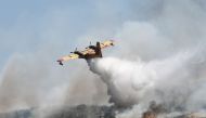 A canadair drop water onto a wildfire near the city of Volos, central Greece, on July 27, 2023. Photo by Sakis MITROLIDIS / AFP