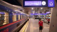 Passengers are seen on the platform in front of the Nightjet train line Vienna - Venice (-Zurich) of the Austrian Federal Railways (OeBB) as a sign shows the destinations and departure time at the main station in Vienna, Austria, on July 25, 2023. (Photo by Alex Halada / AFP)