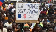 Protesters hold an anti-France placard during a demonstration on independence day in Niamey on August 3, 2023. Niger's junta on August 3 said it was scrapping military pacts made between Niamey and France, following last week's coup. (Photo by AFP) / ALTERNATE CROP
