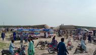 Local residents and ambulances are seen beside carriages following the derailment of a passenger train in Nawabshah, in the Pakistan's southern Sindh province on August 6, 2023. (Photo by AFP)