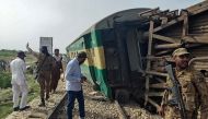 Paramilitary Rangers inspect the carriages following the derailment of a passenger train in Nawabshah, in the Pakistan's southern Sindh province on August 6, 2023. At least 19 people were killed and dozens injured on August 6 when an express train derailed in southern Pakistan, the country's railways minister said. (Photo by AFP)
