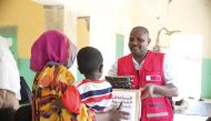 A QRCS official distributes hygiene kits to one of the beneficiaries of the humanitarian response.
