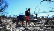 Davilynn Severson and Hano Ganer look for belongings through the ashes of their family痴 home in the aftermath of a wildfire in Lahaina, western Maui, Hawaii on August 11, 2023. (Photo by Patrick T. Fallon / AFP)
