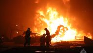This handout photograph taken and released by Russian Emergency Ministry on August 14, 2023, shows rescuers pushing out a fire at a gas station in the city of Makhachkala. (Photo by Handout / Russian Emergency Ministry / AFP)