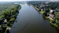 (Files) An aereal view shows Polish firefighters setting up a floating damm to catch dead fish from the river Oder, on August 16, 2022, in Gryfino near Szczecin, Poland. (Photo by Marcin Bielecki / AFP)