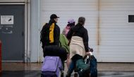 People carry bags near the Emergency response center at the Expo Center on August 18, 2023, in Edmonton, Canada. (Photo by ANDREJ IVANOV / AFP)

