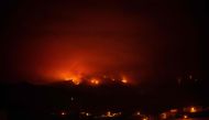 A picture taken in the night of August 19, 2023 shows the fronts of the forest fire on hills above houses, in the Guimar valley on the Canary Island of Tenerife. Photo by DESIREE MARTIN / AFP