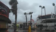 A man walks along a street in Cabo San Lucas, Baja California State, Mexico, as rain and gusts of wind of Hurricane Hilary reach the area, on August 19, 2023. (Photo by Alfredo ESTRELLA / AFP)
