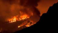 In this picture taken from the village of Sobradillo, late on August 16, 2023 a wildfire rages in a forested area on the Canary island of Tenerife. (Photo by DESIREE MARTIN / AFP)

