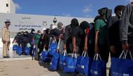 Nigerian migrants who voluntarily chose to return to their home country board a bus before flying out of Libya, during an operation organised by the the International Organisation for Migration (IOM) in Tripoli on August 21, 2023. (Photo by Mahmud Turkia / AFP)