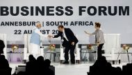 Prime Minister of India Narendra Modi (left) shakes hands with China's Minister of Commerce Wang Wentao as Former President of Brazil and chair of the New Development Bank Dilma Rousseff (right) looks on during the 2023 BRICS Summit at the Sandton Convention Centre in Johannesburg on August 22, 2023. (Photo by Marco Longari / AFP)