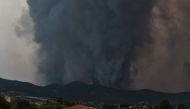 Smoke billows from a forest as wildfire rages in Kasiteres near Komotini, on August 23, 2023. (Photo by Sakis Mitrolidis / AFP)