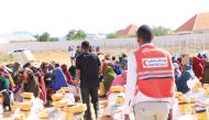 QRCS and KRCS volunteers distributing food aid among internally displaced people in Somalia.