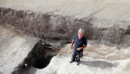 Remi Martineau, researcher at the CNRS, stands at the mouth of a well, dating from the Modern Neolithic, around 3500-years-ago, from a settlement suggesting the presence of a village occupied by a structured population, at Val-des-Marais in the south of the Marne, on August 23, 2023. (Photo by Francois Nascimbeni / AFP)
 