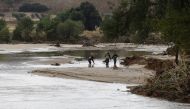 Officers of the Guardia Civil search through a river in the town of Aldea del Fresno, in the Madrid region on September 4, 2023, as a man was reported missing after his vehicle was swept away by an overflowing river during heavy rains, according to Madrid's emergency services. Photo by Oscar DEL POZO CAÑAS / AFP