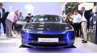 Visitors inspect a Tesla model 3 car on display at the International Motor Show (IAA) in Munich, southern Germany, on September 4, 2023. (Photo by Tobias Schwarz / AFP)