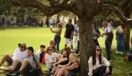People take shelter from the sun in the shade of a tree in central London on September 8, 2023 as the late summer heatwave continues. (Photo by Daniel Leal / AFP)

