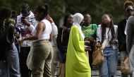 A young woman wearing an abaya speaks with others on a street in Nantes, western France on August 31, 2023. (Photo by Loic Venance / AFP)

