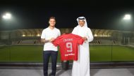 Philippe Coutinho holds his team jersey with Al Duhail Club Vice President Khalifa Khamis, after the official contract was signed yesterday.