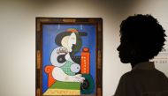 A visitor looks over Pablo Picasso’s painting Femme ل la montre, the painting will be auctioned in November as part of the Emily Fisher Landau Collection and is expected to fetch $120 million, pictured on display at Sotheby’s on September 13, 2023 in New York. (Photo by Bryan R. Smith / AFP)
