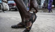 A man wears his Leke shoes in Treichville, Abidjan, on September 14, 2023. (Photo by Sia KAMBOU / AFP)
