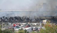 Rescuers work as smoke stills rising on September 28, 2023 at the site of an explosion at a warehouse near the airport in Tashkent that caused multiple injuries (Photo by Temur Ismailov / AFP)