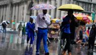 People walk under umbrellas during a coastal storm in Lower Manhattan on September 29, 2023 in New York City. (Photo by Eduardo Munoz Alvarez/Getty Images/AFP)