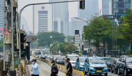People cross a street on a polluted day in Jakarta on October 1, 2023. Photo by BAY ISMOYO / AFP
