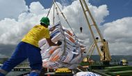 Workers unload rice imported from Vietnam by the Indonesian Logistics Bureau at the port of Malahayati, in Indonesia's Aceh province on October 11, 2023. (Photo by CHAIDEER MAHYUDDIN / AFP)
