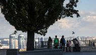 People look at the skyline of the Kyiv from a park, on October 27, 2023. (Photo by Anatolii Stepanov / AFP)
