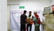 QRCS team distributing food parcels to Palestinians sheltered at the Al Amal Hospital in Khan Yunis governorate.