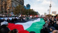 Demonstrators carry a giant Palestinian flag during a protest in support of Palestinians under the slogan 'Free Palestine' with the TV Tower in the background in Berlin, Germany on November 4, 2023. (Photo by Odd ANDERSEN / AFP)

