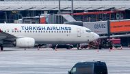A police van observe the car of a hostage taker seen parked under a Turkish airline plane on the tarmac at the airport in Hamburg, northern Germany on November 5, 2023. (Photo by NEWS5 / Schrِder / NEWS5 / AFP)
