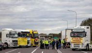 Transport company owners stand together as they with their vehicles block access to the Polish-Ukrainian border crossing in Dorohusk, Poland on November 6, 2023 to protest against 'unfair' competition. (Photo by Wojtek Radwanski / AFP)
