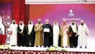 Minister of Awqaf and Islamic Affairs H E Ghanem bin Shaheen bin Ghanem Al Ghanim with officials and the winner of 'Awal Al Awail' title of the holy Quran contest.