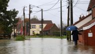 A woman walks in a flooded street in Le Doulac near Saint-Omer, northern France on November 14, 2023, as the Pas-de-Calais region was hit by torrential rains with a historic rise in water levels on November 7, 2023. Photo by Aurelien Morissard / POOL / AFP