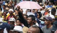 Supporters cheer as members of the collective of opposition candidates march through the streets of Analamahitsy district to protest against the holding of the 2023 Presidential Election, in Antananarivo, on November 14, 2023. (Photo by RIJASOLO / AFP)
