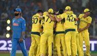 India's Ravindra Jadeja (L) walks past Australia's players celebrating their win in the 2023 ICC Men's Cricket World Cup one-day international (ODI) final match between India and Australia at the Narendra Modi Stadium in Ahmedabad on November 19, 2023. (Photo by Punit PARANJPE / AFP)