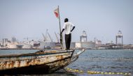 A fisherman looks on from his boat in the polluted Hann Bay in Dakar, on September 27, 2023. (Photo by John Wessels / AFP)