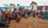 Women who fled the war in Sudan await the distribution of international aid rations at the Ourang refugee camp, near Adre town in eastern Chad on August 15, 2023. (Photo by Mohaned Belal / AFP)