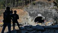 Media personnel stand near an entrance of the Silkyara under construction road tunnel in the Uttarkashi district of India's Uttarakhand state on November 23, 2023. (Photo by Arun Sankar / AFP)