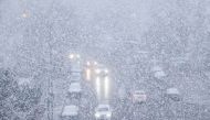 Cars make their way during snowfall in Dalian, in China's northeastern Liaoning province on November 23, 2023. Photo by AFP