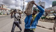 File: Opposition supporters carry stones and chant slogans demanding lower taxes and a reduced cost of living in Nairobi, Kenya, on March 20, 2023. Kenyans face economic hardship following the government's recent tax measures and increased food and fuel prices. (Photo by Luis Tato / AFP)