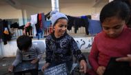 Displaced Palestinian children gather in the courtyard of the Taha Hussein school which is used as a temporary shelter in Rafah in the southern Gaza Strip on November 29, 2023. (Photo by Mahmud Hams / AFP)