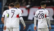 Paris Saint-Germain's French forward #07 Kylian Mbappe (C) and Paris Saint-Germain's Spanish midfielder #28 Carlos Soler stand as they are wearing a jersey flocked in corean, during the French L1 football match between Le Havre AC and Paris Saint-Germain (PSG) at The Stade Oceane in Le Havre, north-western France, on December 3, 2023. (Photo by DAMIEN MEYER / AFP)
