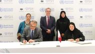 Minister of Public Health H E Dr. Hanan Mohamed Al Kuwari looks on as WHO chief Dr. Tedros Adhanom Ghebreyesus (left) and WISH CEO Sultana Afdhal sign the document.