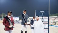 Head of Qatari equestrian teams Abdulla Al Marri presents the Medium Tour winner's trophy to Saeed Nasser Al Qadi on Day 1 of the sixth round of the Longines Hathab Qatar Equestrian Tour, at the Qatar Equestrian Federation’s outdoor arena, yesterday. 