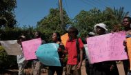 Party supporters hold placards as they protest outside the home of recalled Member of Parliament for Mabvuku-Tafara constituency, Munyaradzi Kufahakutizwi of the Citizens Coalition for Change (CCC) opposition party, in Harare on December 9, 2023 after his candidature was disqualified by the courts in the current by-elections held in Zimbabwe. (Photo by Jekesai NJIKIZANA / AFP)
