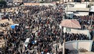 Palestinians gather to receive flour rations for their families outside a warehouse of the United Nations Relief and Works Agency for Palestine Refugees (UNRWA) in Rafah in the southern Gaza Strip on December 12, 2023. Photo by MOHAMMED ABED / AFP