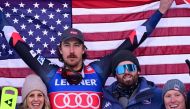 First placed US' Bryce Bennett celebrates with team members on the podium after winning the men's downhill replacing Zermatt-Cervinia's race, during the FIS Alpine Ski World Cup in Val Gardena on December 14, 2023. (Photo by Tiziana FABI / AFP)

